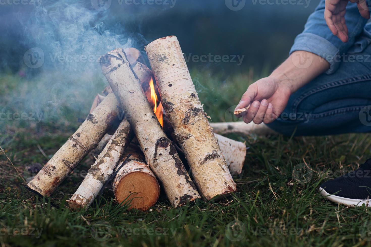 les mains de l'homme allument un feu dans les montagnes. photo