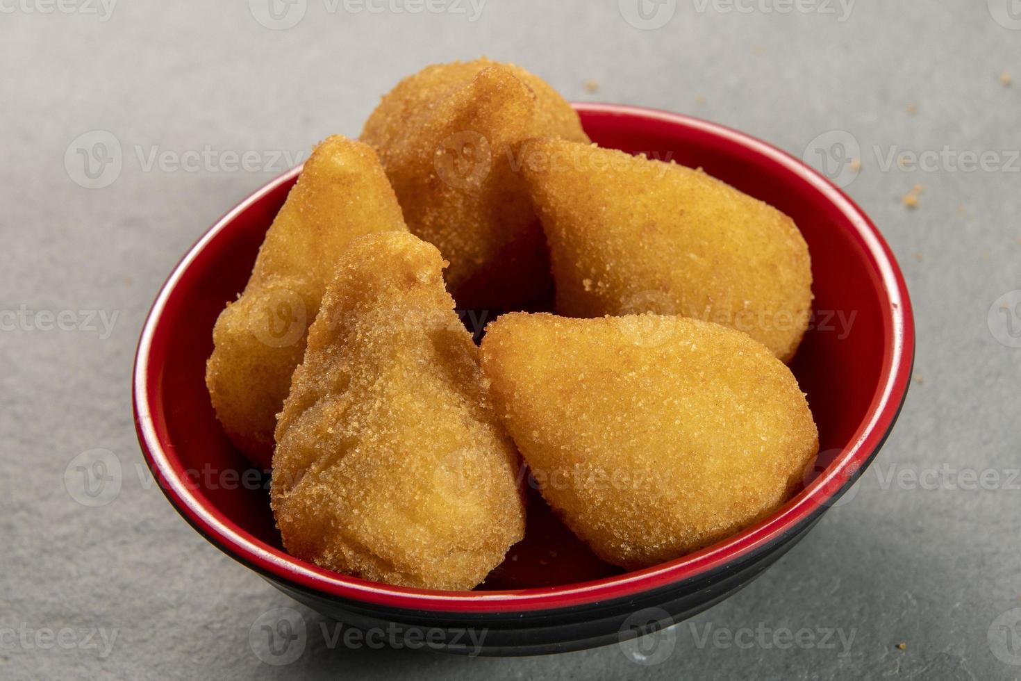 traditionnel frit coxinha dans assiette sur ardoise arrière-plan, populaire brésilien casse-croûte photo