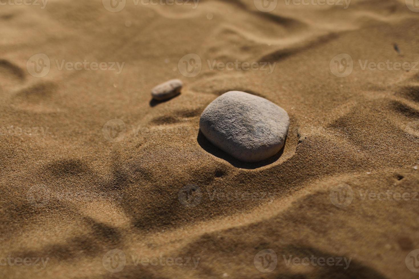 pierres sur le fond de la plage de sable. papier peint naturel, texture. mise au point sélective. copie espace. photo