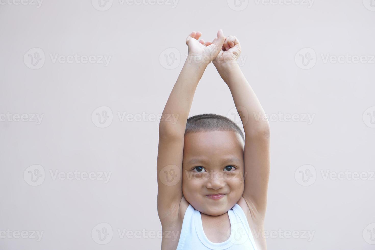 asiatique garçon souriant Heureusement élever votre main en haut photo