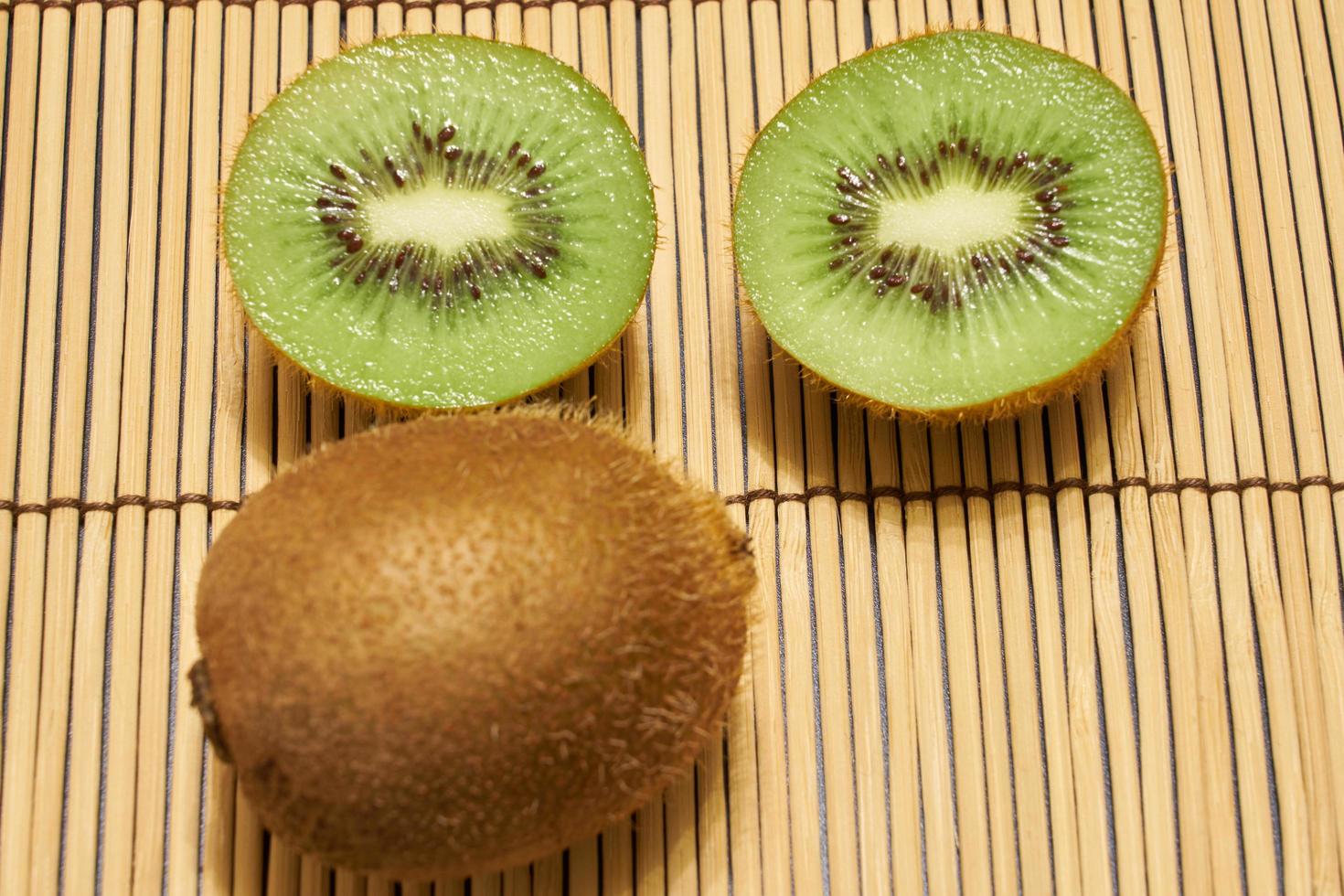 kiwi brun mûr avec kiwi vert coupé sur fond de paille avec un espace pour le texte. photo