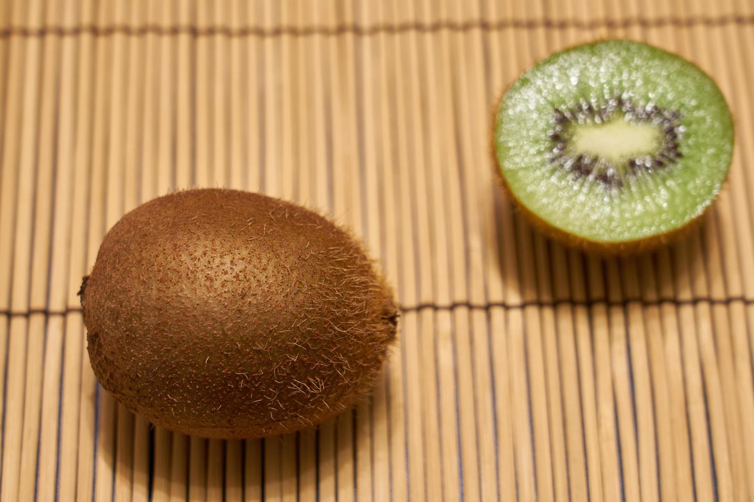 kiwi brun mûr avec kiwi vert coupé sur fond de paille avec un espace pour le texte. photo