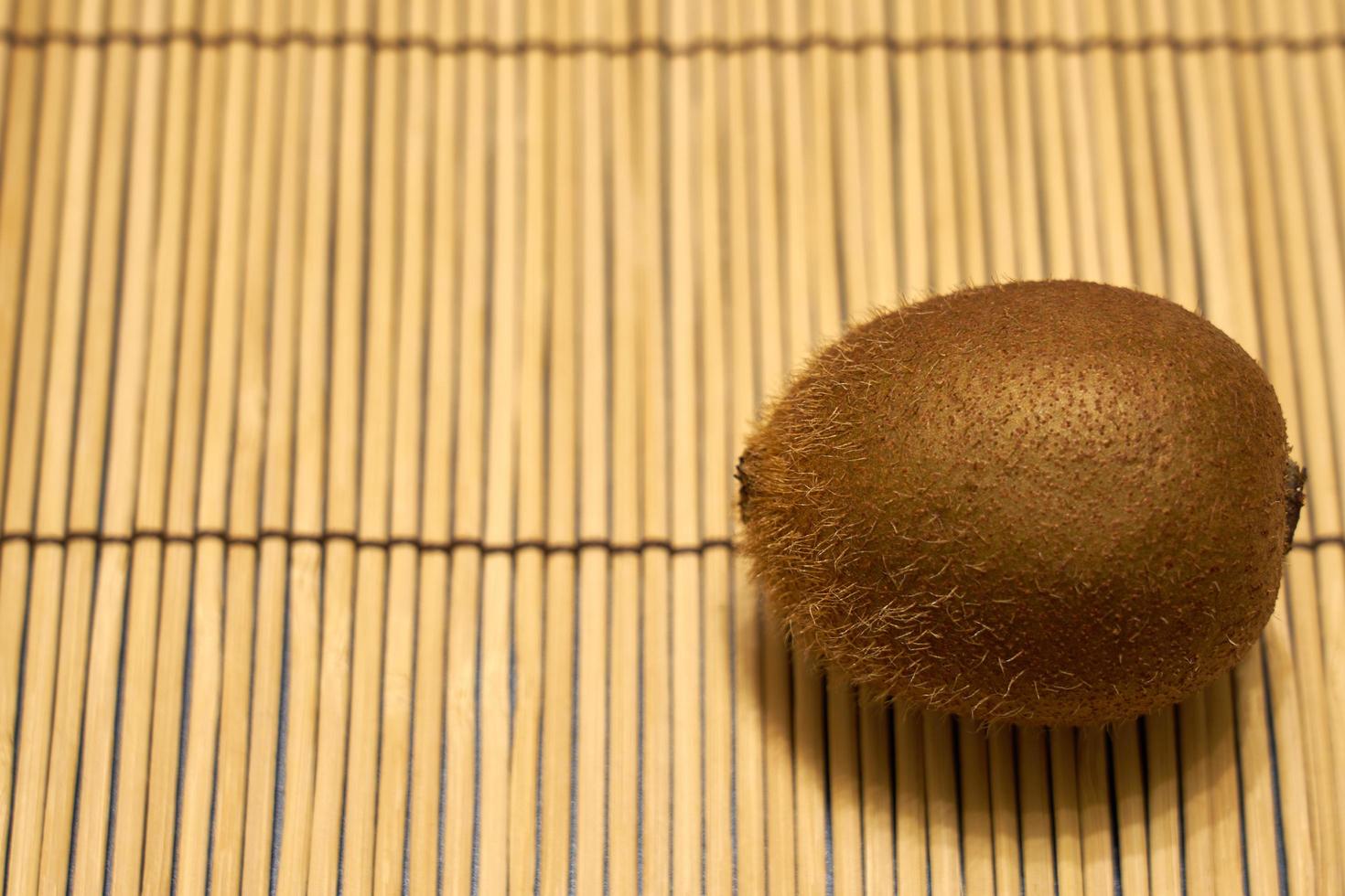 kiwi brun mûr sur fond de paille. photo