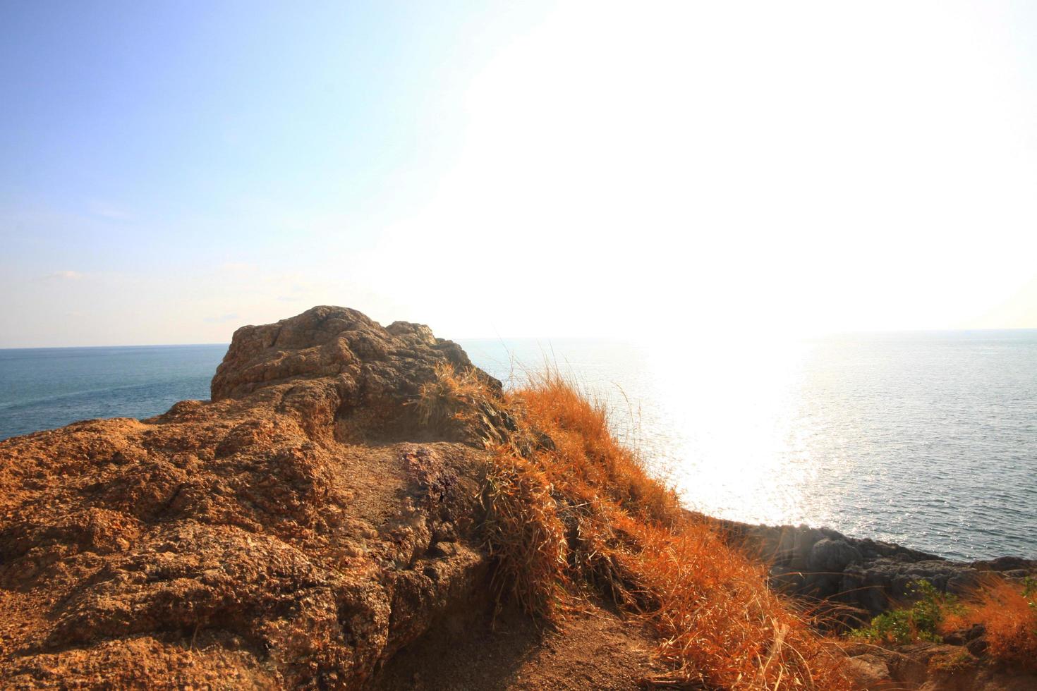 magnifique paysage marin avec ciel crépuscule de le coucher du soleil et mer horizon avec calme et bleu ciel sec herbe champ sur Montagne de phrom thep cap est célèbre endroit dans phuket île, Thaïlande. photo