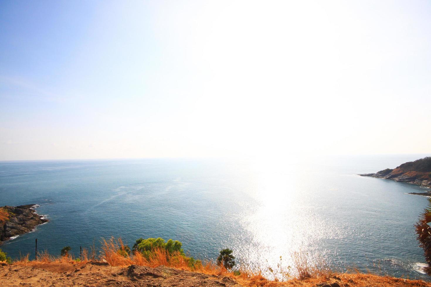 magnifique paysage marin avec ciel crépuscule de le coucher du soleil et mer horizon avec calme et bleu ciel sec herbe champ sur Montagne de phrom thep cap est célèbre endroit dans phuket île, Thaïlande. photo