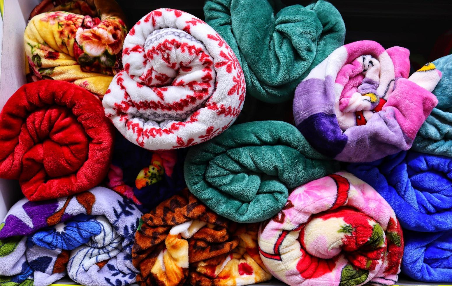 brillant Célibataire multi coloré lit couvertures rouleau dans étagères photo