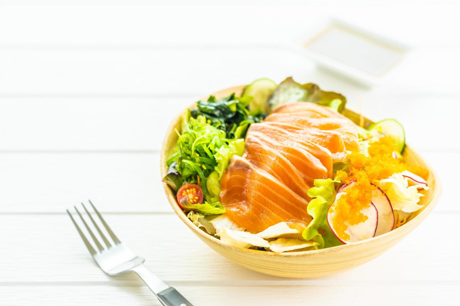 Sashimi de viande de poisson saumon frais cru avec salade d'algues et autres légumes photo