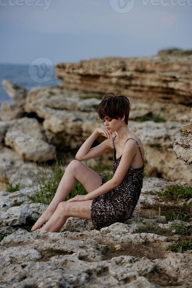 magnifique femme séance sur le des pierres paysage la nature en plein air photo