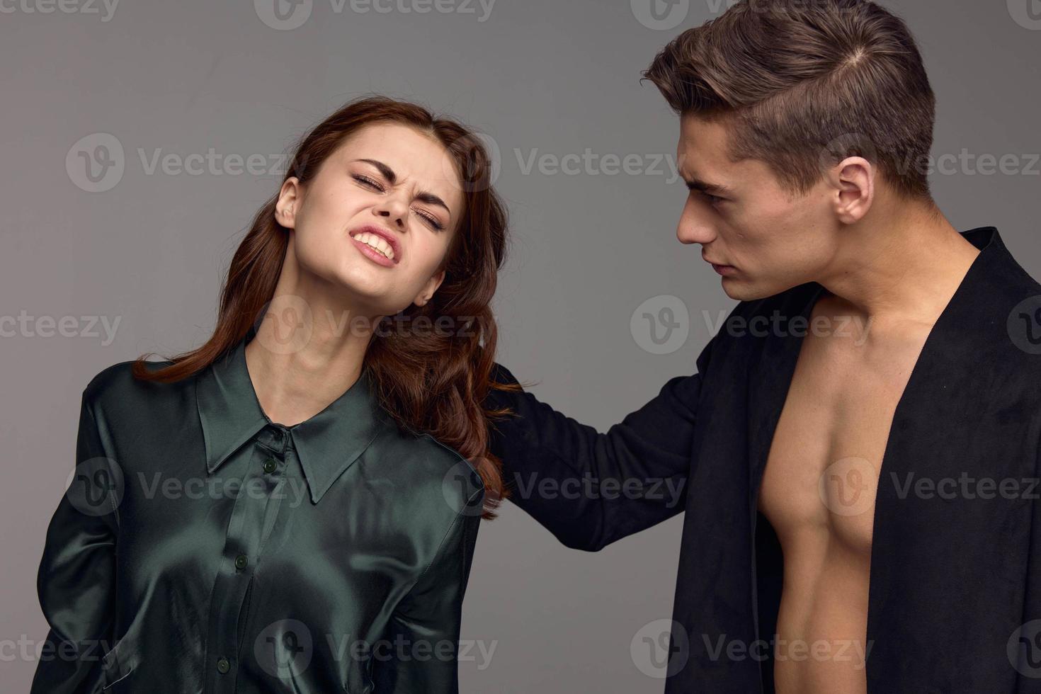 une homme tire le cheveux de une roux femme sur une gris Contexte photo