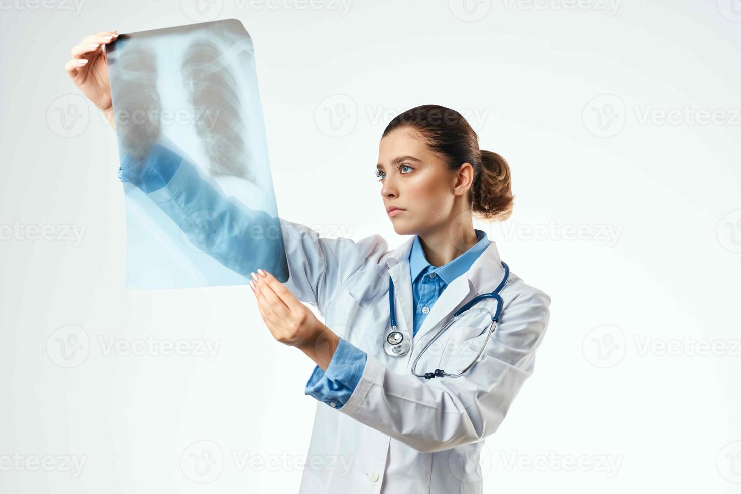 femelle médical professionnel dans une blanc manteau à la recherche à un radiographie à une professionnel photo