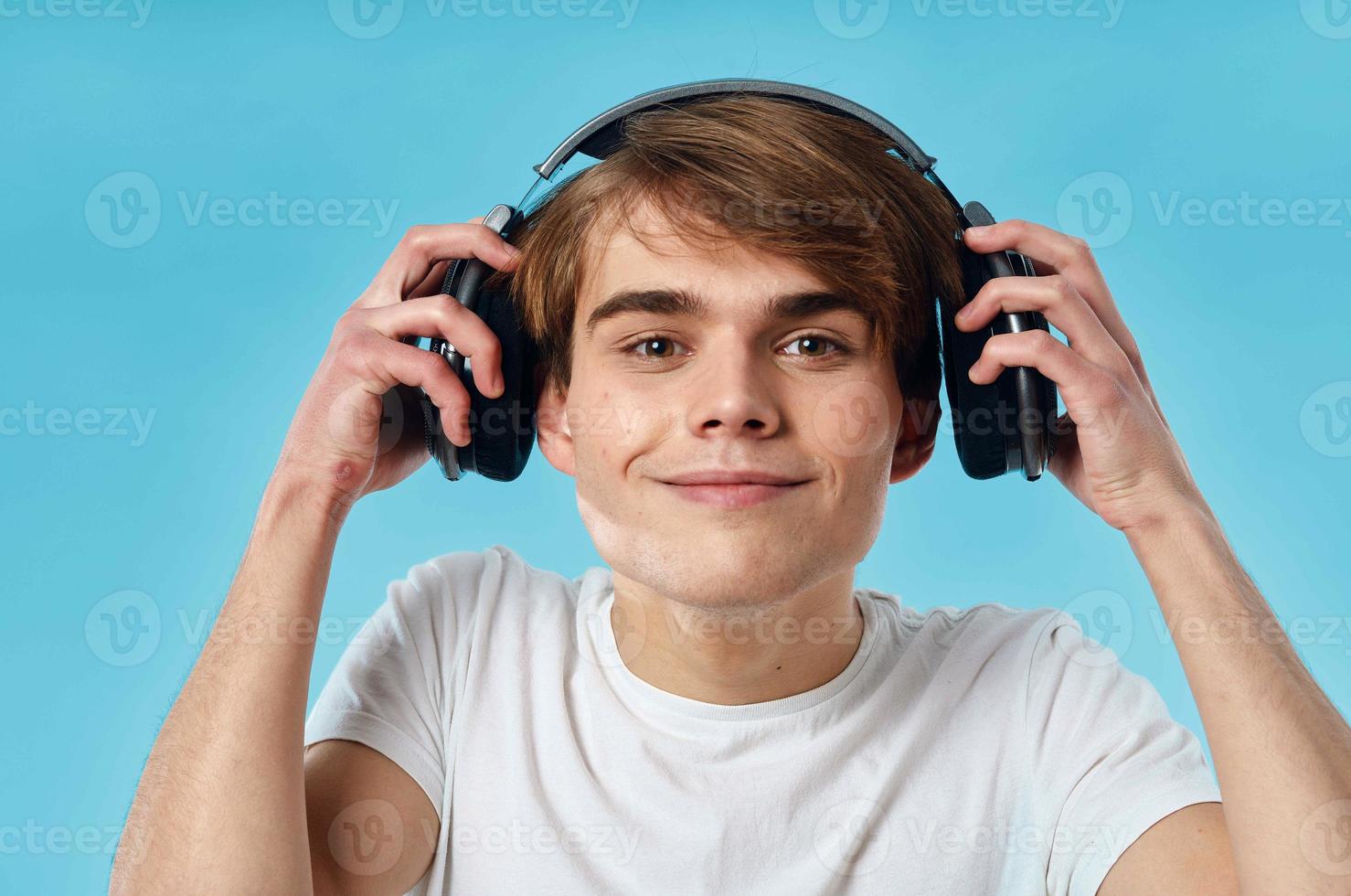 gars dans blanc T-shirt portant écouteurs émotions la musique La technologie bleu Contexte photo