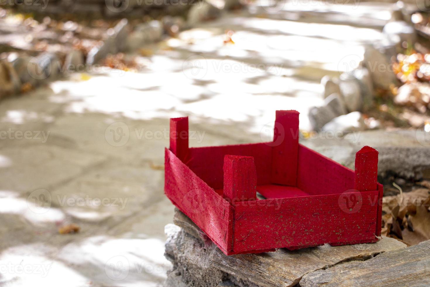 rouge en bois panier sur une pierre dans le jardin. le rouge en bois boîte sur une pierre mur dans le Cour de le maison photo