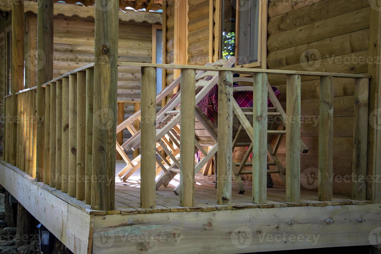 en bois clôture, tableau, et chaises de une en bois maison dans le village. terrasse de une pays maison. photo