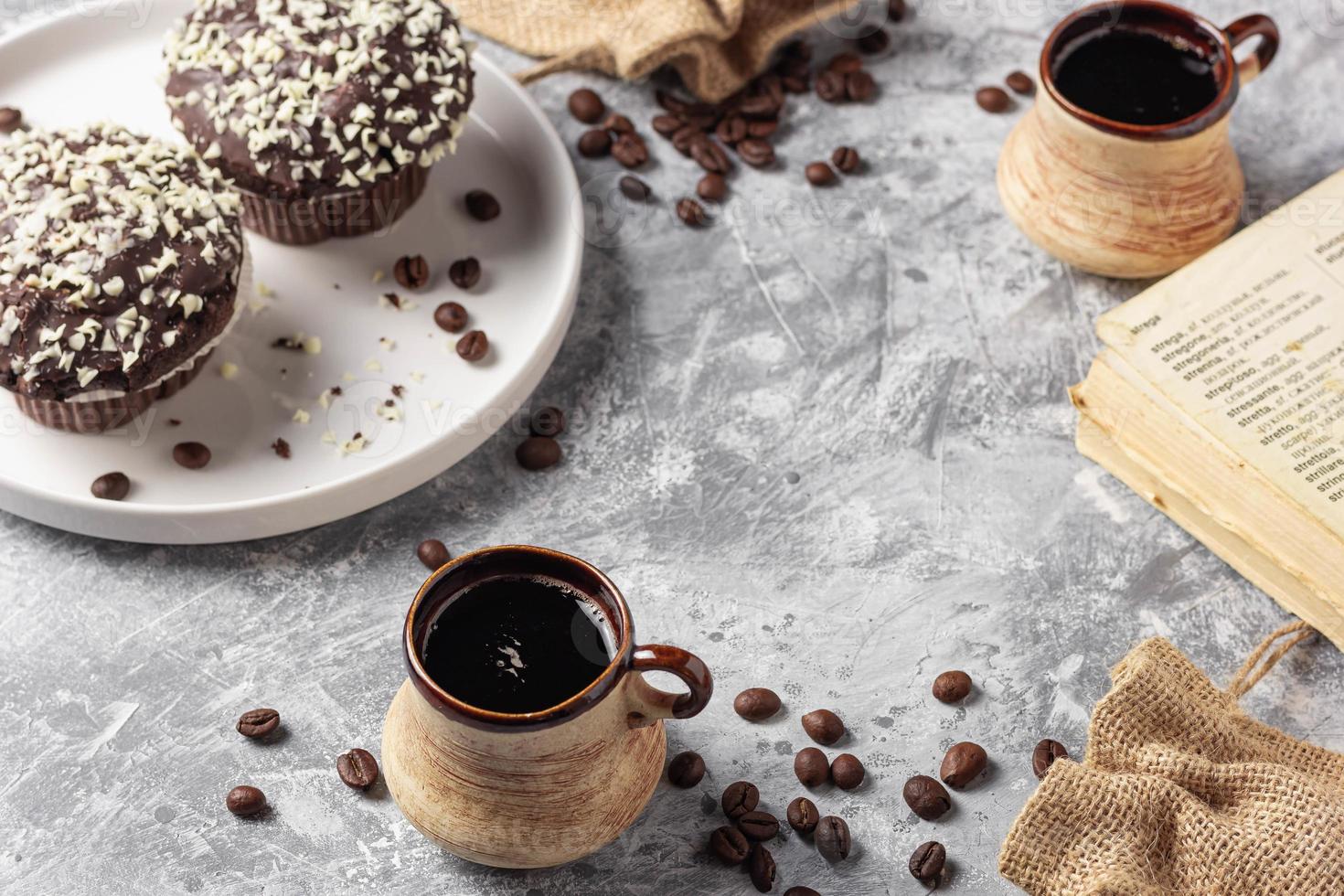 rôti café des haricots dans tasse et gâteau sur gris texturé Contexte photo