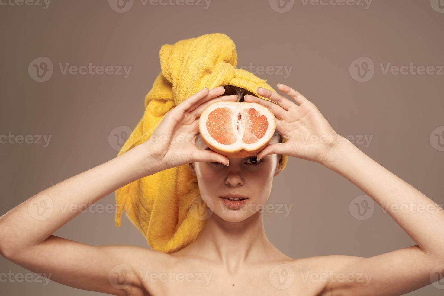femme avec pamplemousse dans mains nu épaules et peau se soucier vitamines photo