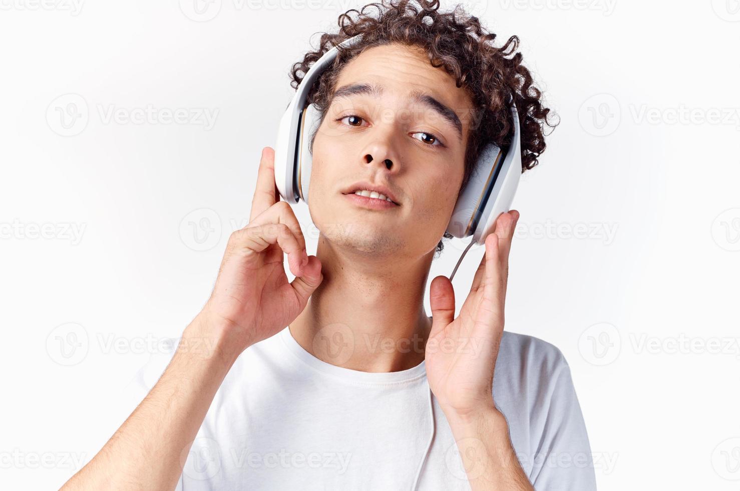 une homme dans une blanc T-shirt avec écouteurs écoute à la musique émotions joie jouissance photo