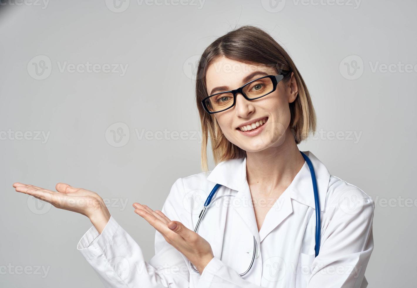médecin avec une stéthoscope spectacles le sien main à le côté sur une gris Contexte copie espace photo