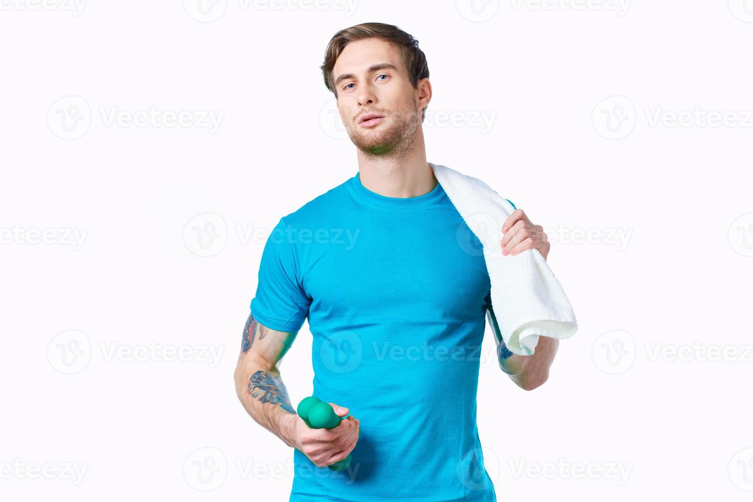 Beau homme dans blanc T-shirt tatouage sur bras faire des exercices tondu vue photo