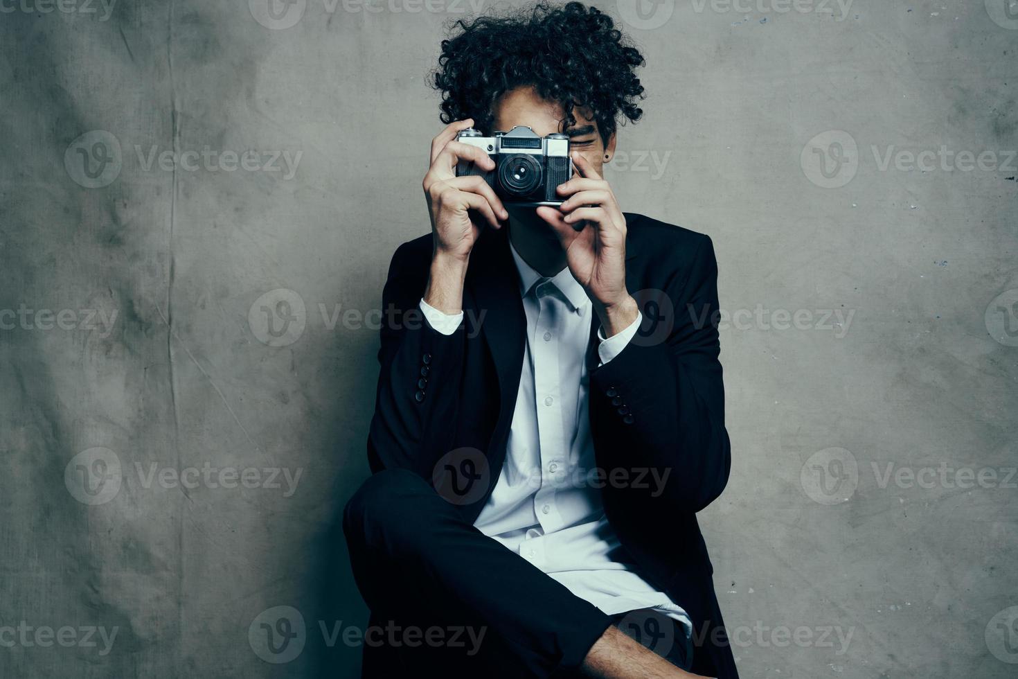 Beau homme dans studio avec caméra en tissu Contexte classique costume modèle photo