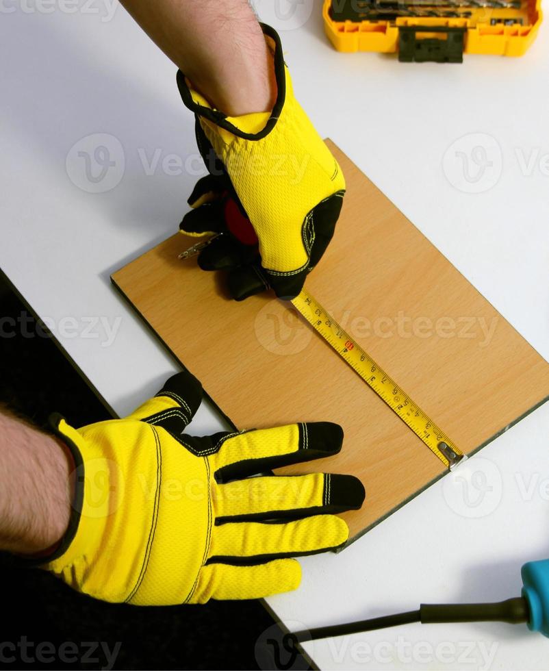 mains de une homme dans protecteur gants mesure le distance avec une ruban mesure photo