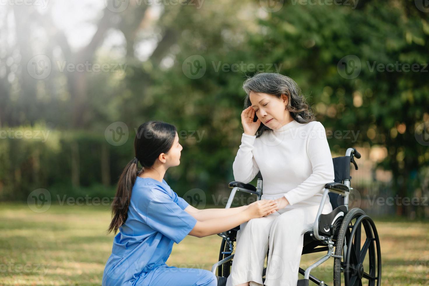 personnes âgées asiatique Sénior femme sur fauteuil roulant avec asiatique prudent soignant. allaitement Accueil hôpital jardin concept. dans Soleil lumière photo