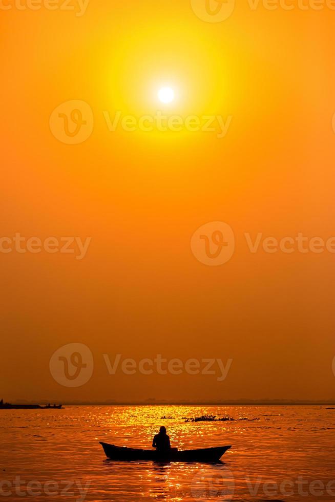 soir d'or le coucher du soleil temps, une pêcheur pêche sur le bord de mer sur une bateau. photo