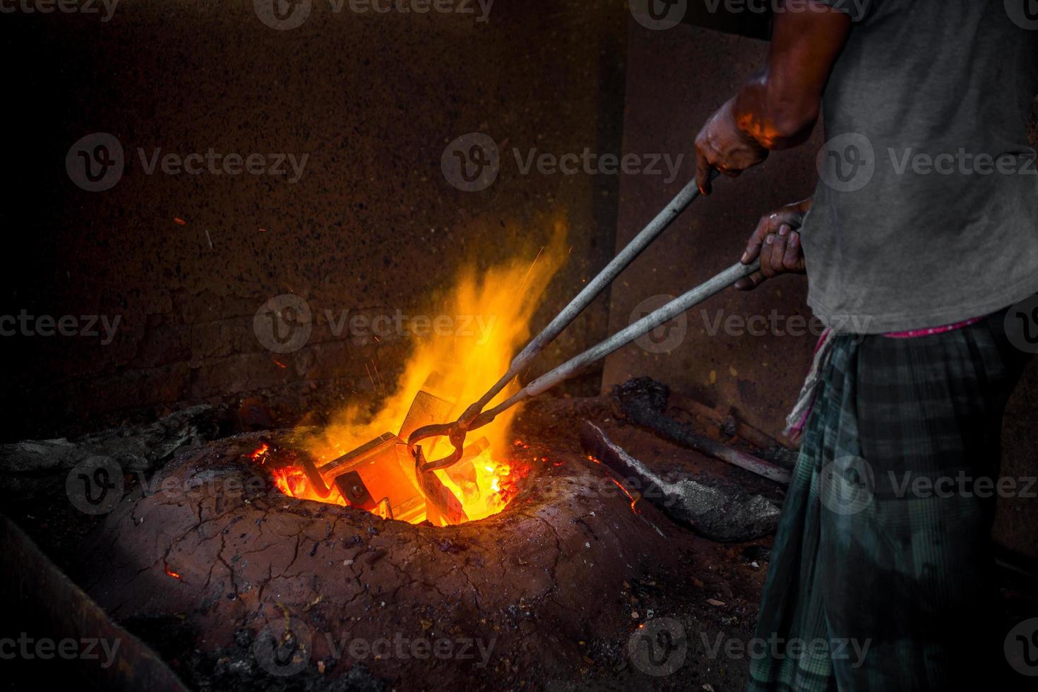 peu sûr ouvrier mains. une local acier machine les pièces fabrication Cour ouvrier fusion ferraille sur chaud fourneau. photo