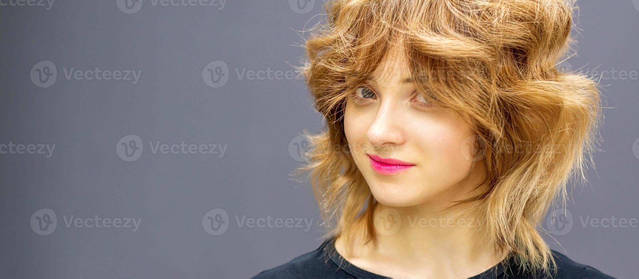 magnifique Jeune caucasien femme avec une rouge court frisé coiffure sur foncé Contexte. photo