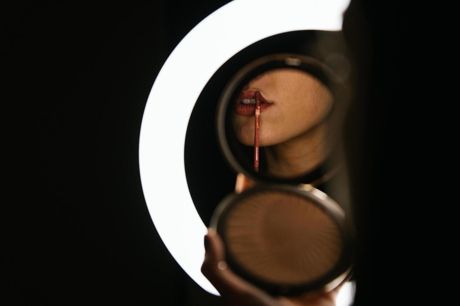 belle femme peignant ses lèvres en rouge photo