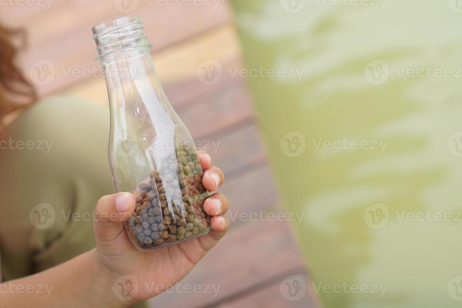 enfant main alimentation le poisson dans le étang photo