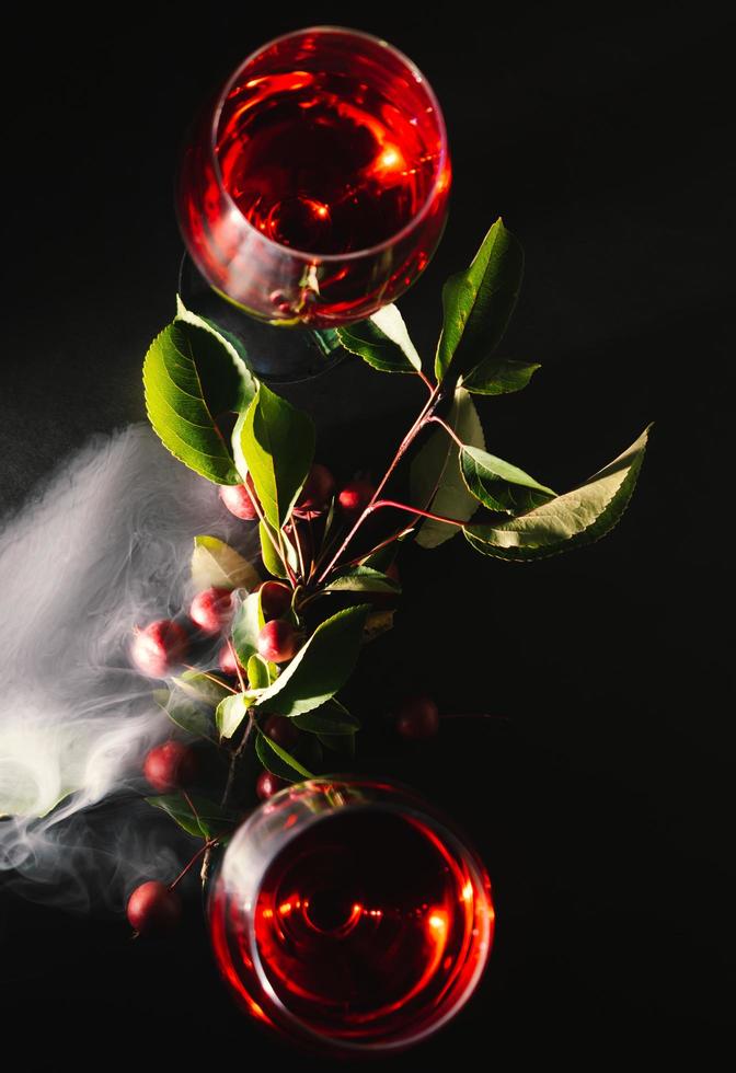 deux du vin des lunettes entouré avec fumée sur une noir Contexte photo