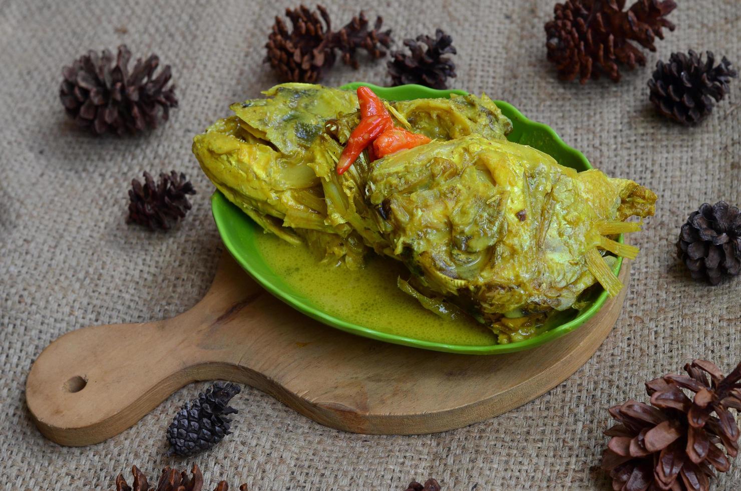 gulai képala kakap ou vivaneau poisson diriger, cuit dans curry assaisonnement, il goûts épicé, acide et sarriette. traditionnel padang cuisine, Ouest Sumatra, Indonésie. photo