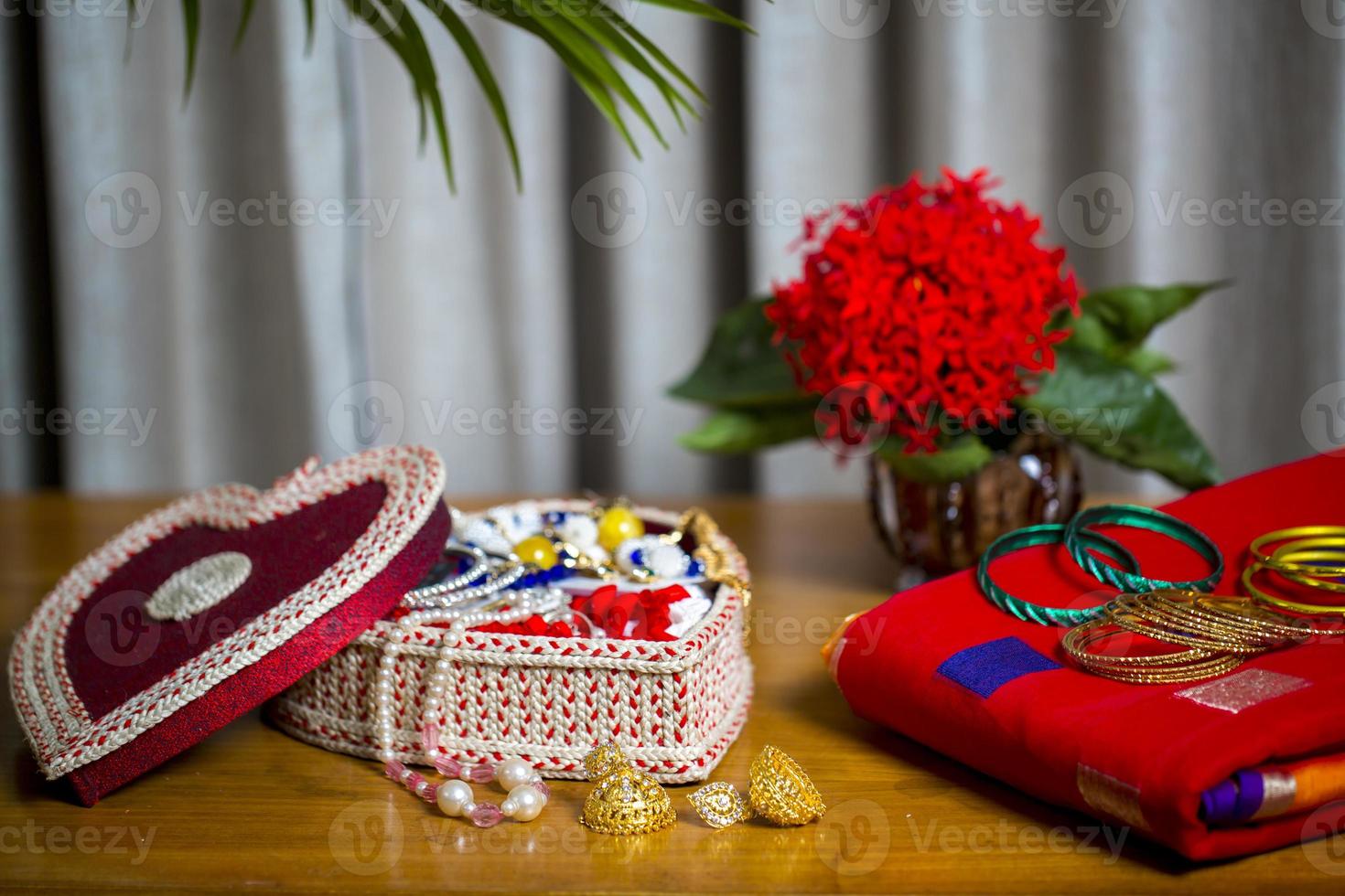 Fait main fibre ornements boîte avec traditionnel bijoux sur le en bois tableau. Indien traditionnel bijoux et de mariée sari. photo