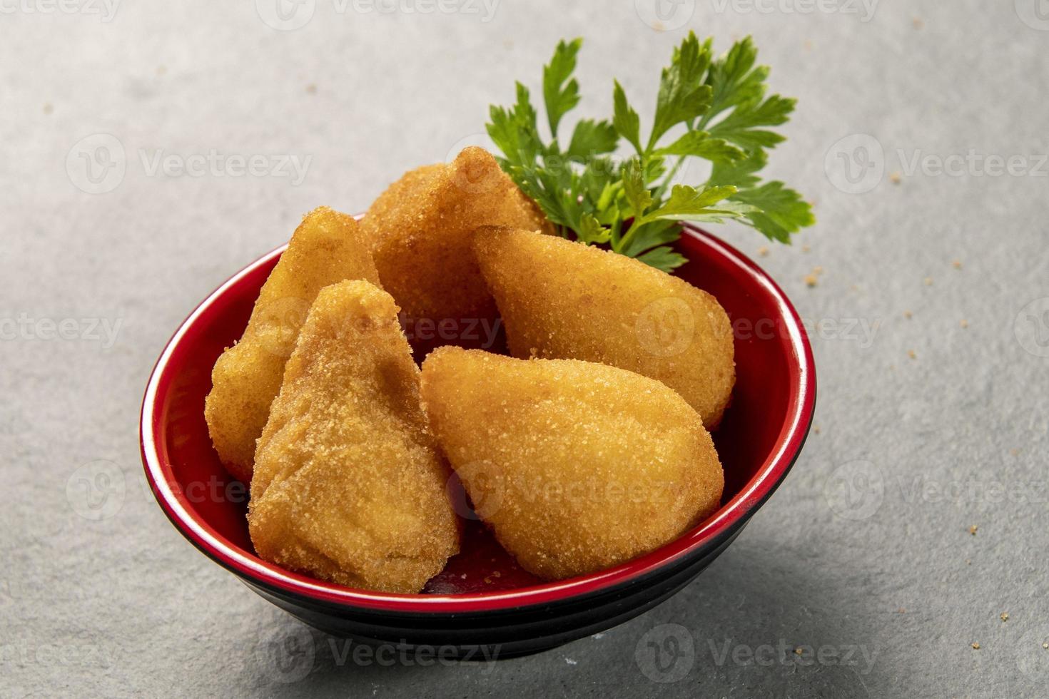 traditionnel frit coxinha dans assiette sur ardoise arrière-plan, populaire brésilien casse-croûte photo