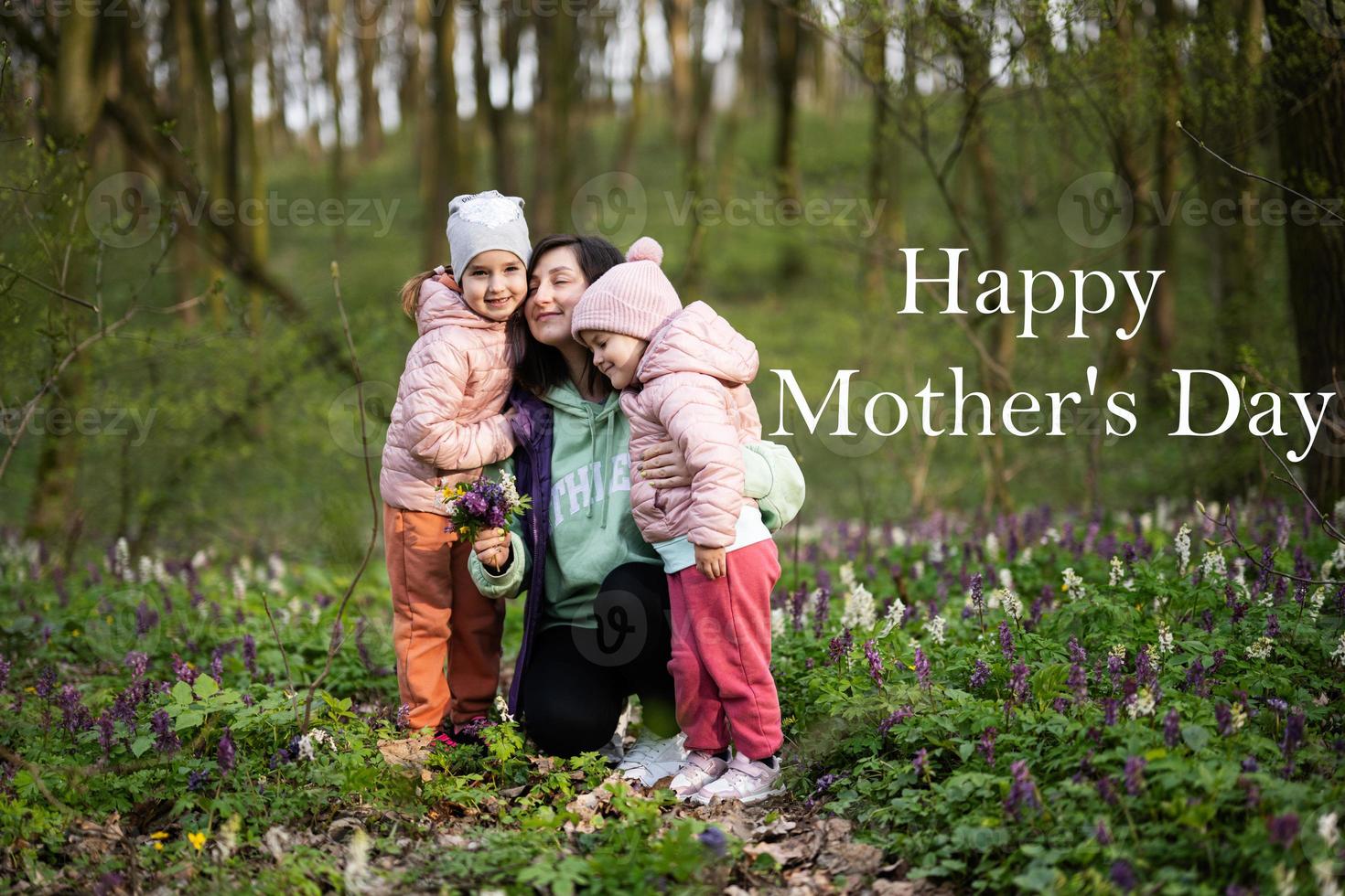 content de la mère journée. nous l'amour toi, maman. mère avec une bouquet de fleurs et deux filles dans printemps épanouissement forêt. photo