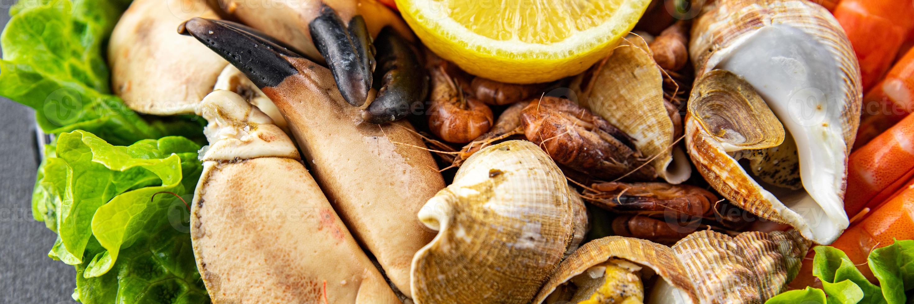 Fruit de mer assiette assorti crevettes, Crabe les griffes, palourdes, rapan, trompette mollusque repas nourriture casse-croûte sur le table copie espace nourriture Contexte rustique Haut vue photo