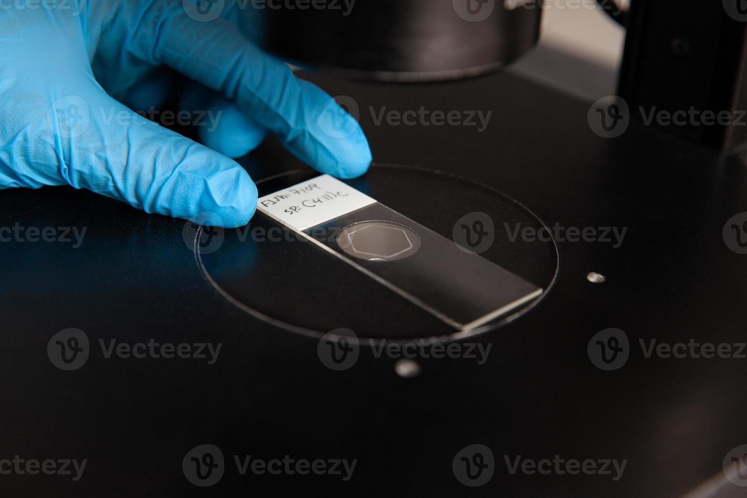 scientifique à la recherche à diapositives avec patient échantillons en utilisant un inversé microscope dans le laboratoire. fluorescence dans situé hybridation technique. photo