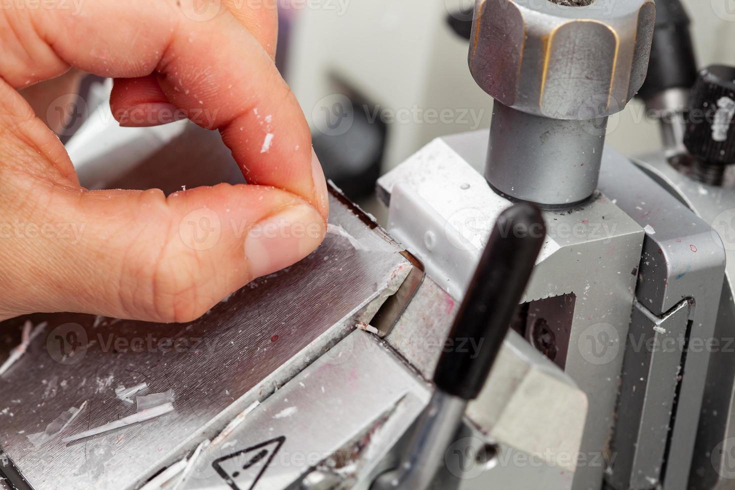 fermer à le scientifique mains travail sur une rotatif microtome à obtenir sections de une inclus en paraffine spécimen. photo