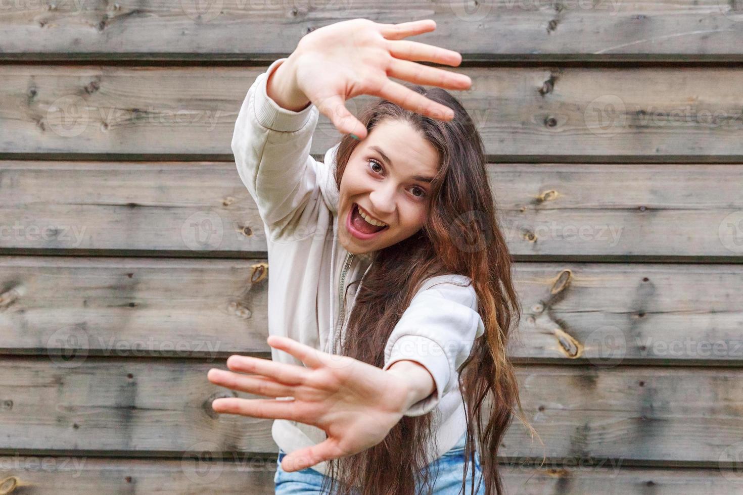 fille heureuse souriante. portrait de beauté jeune femme brune riante positive heureuse sur fond de mur en bois photo