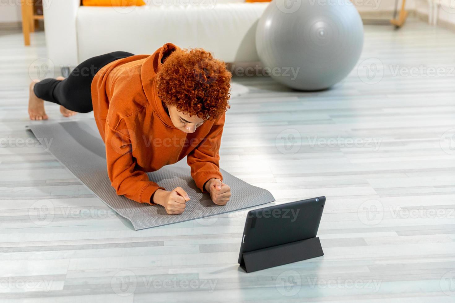 aptitude faire des exercices entraînement. Jeune en bonne santé en forme africain fille Faire planche exercice sur yoga tapis sur sol à maison. athlétique femme dans tenue de sport formation pilates. sport et aptitude. photo