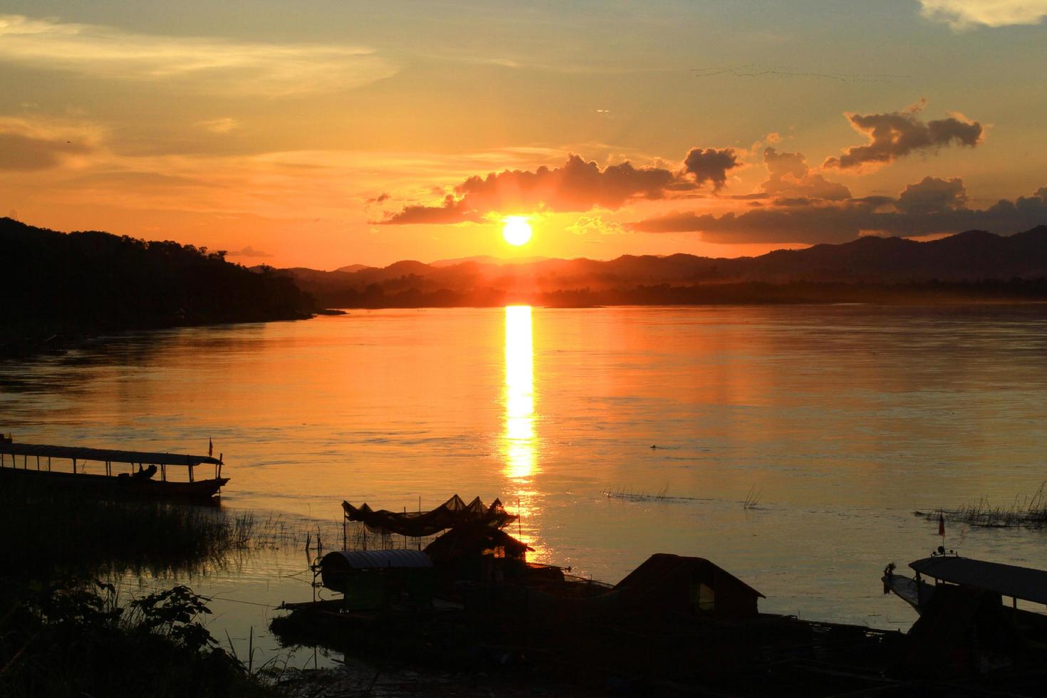 tradition de longue queue bateau et pêcheur dans magnifique le coucher du soleil crépuscule à khong rivière le thaï-laos frontière chaingkhan distric Thaïlande photo