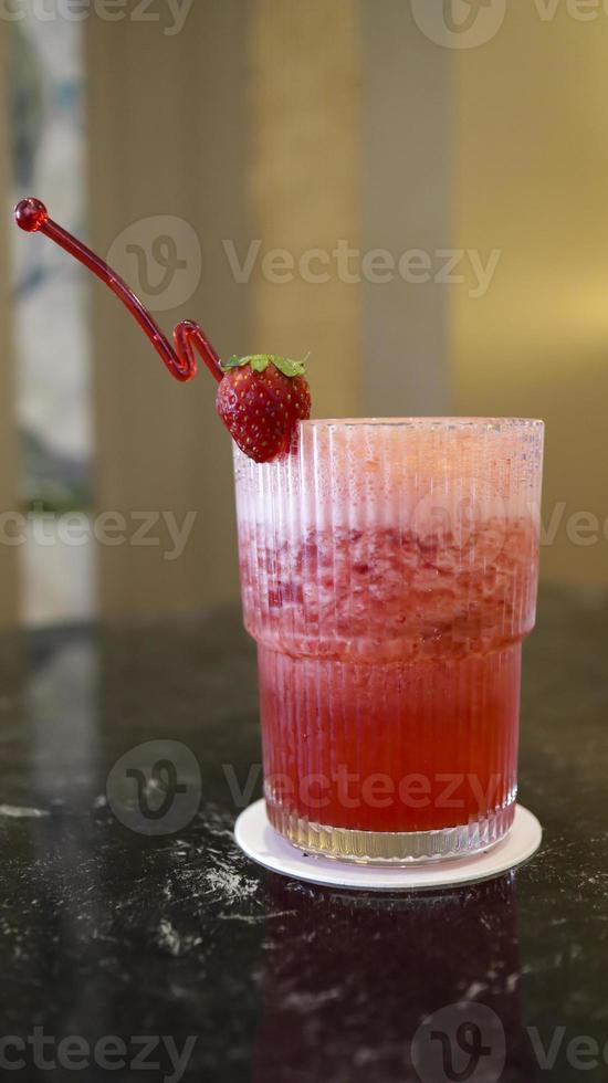 une verre de fraise jus à le table avec une fantaisie paille. photo