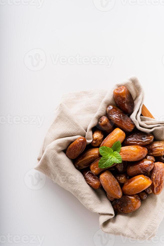 séché Rendez-vous fruit dans en bois plateau avec doux serviette de table isolé sur blanc Contexte. photo