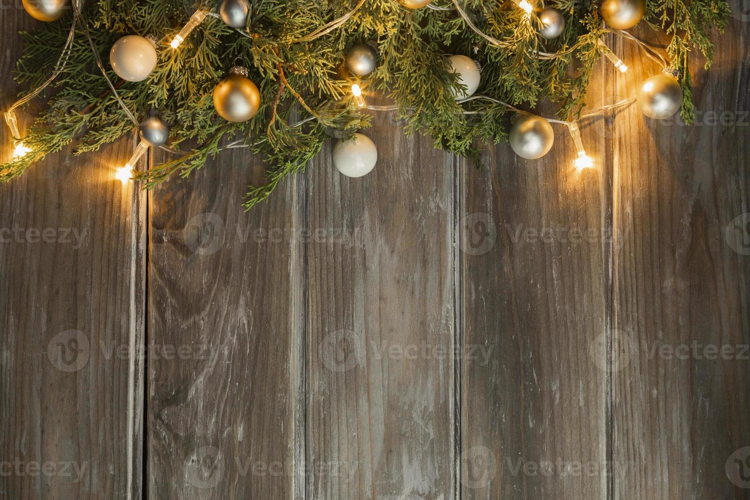 Cadre plat poser avec des lumières illuminées de sapin de Noël sur fond de bois photo