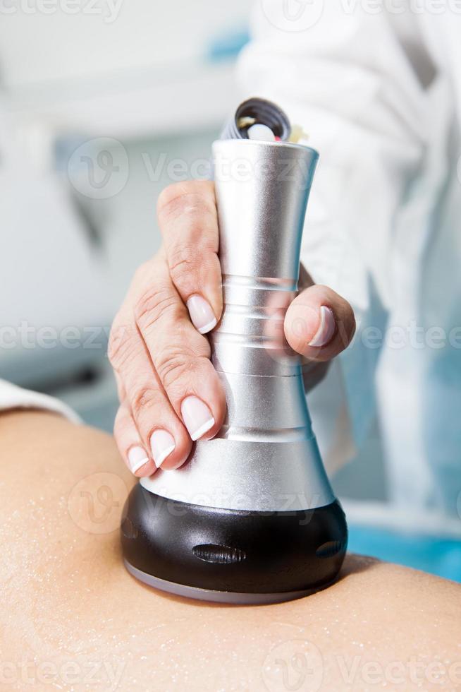 médecin performant un ultracavitation traitement sur une Jeune femelle patient jambe photo