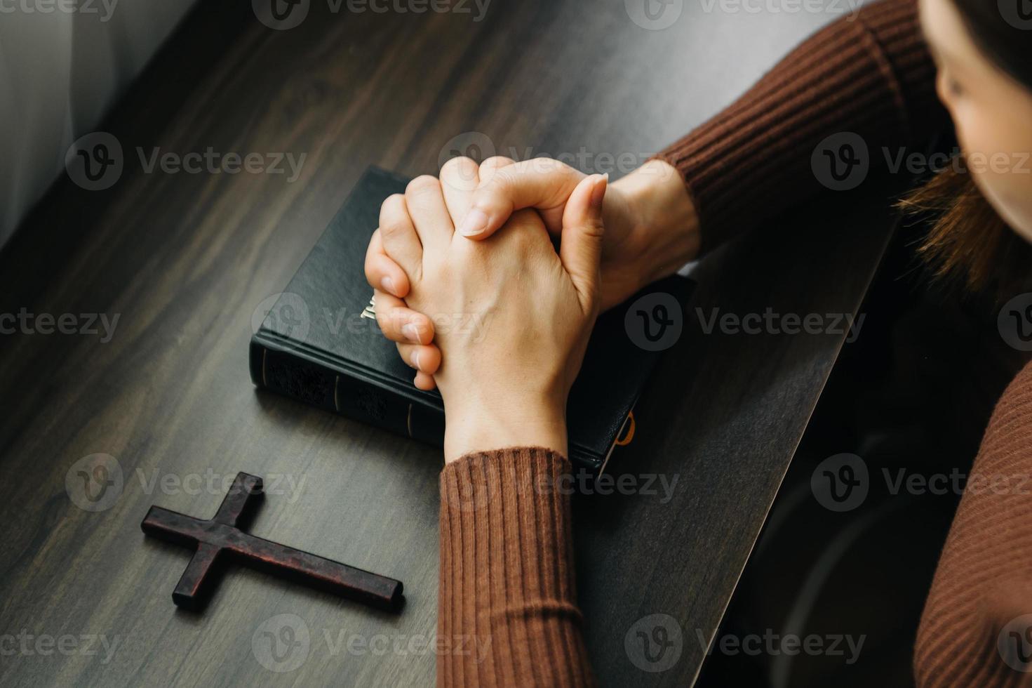 les mains ensemble dans la prière à dieu avec la bible dans le concept chrétien et la religion, la femme prie dans la bible photo