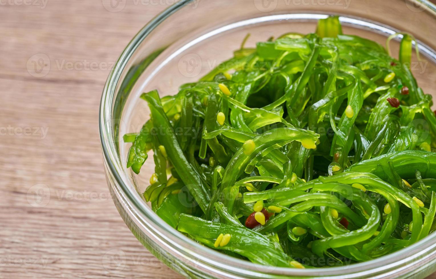 proche en haut wakame algue salade avec sésame la graine dans des lunettes bol sur bois table Contexte photo