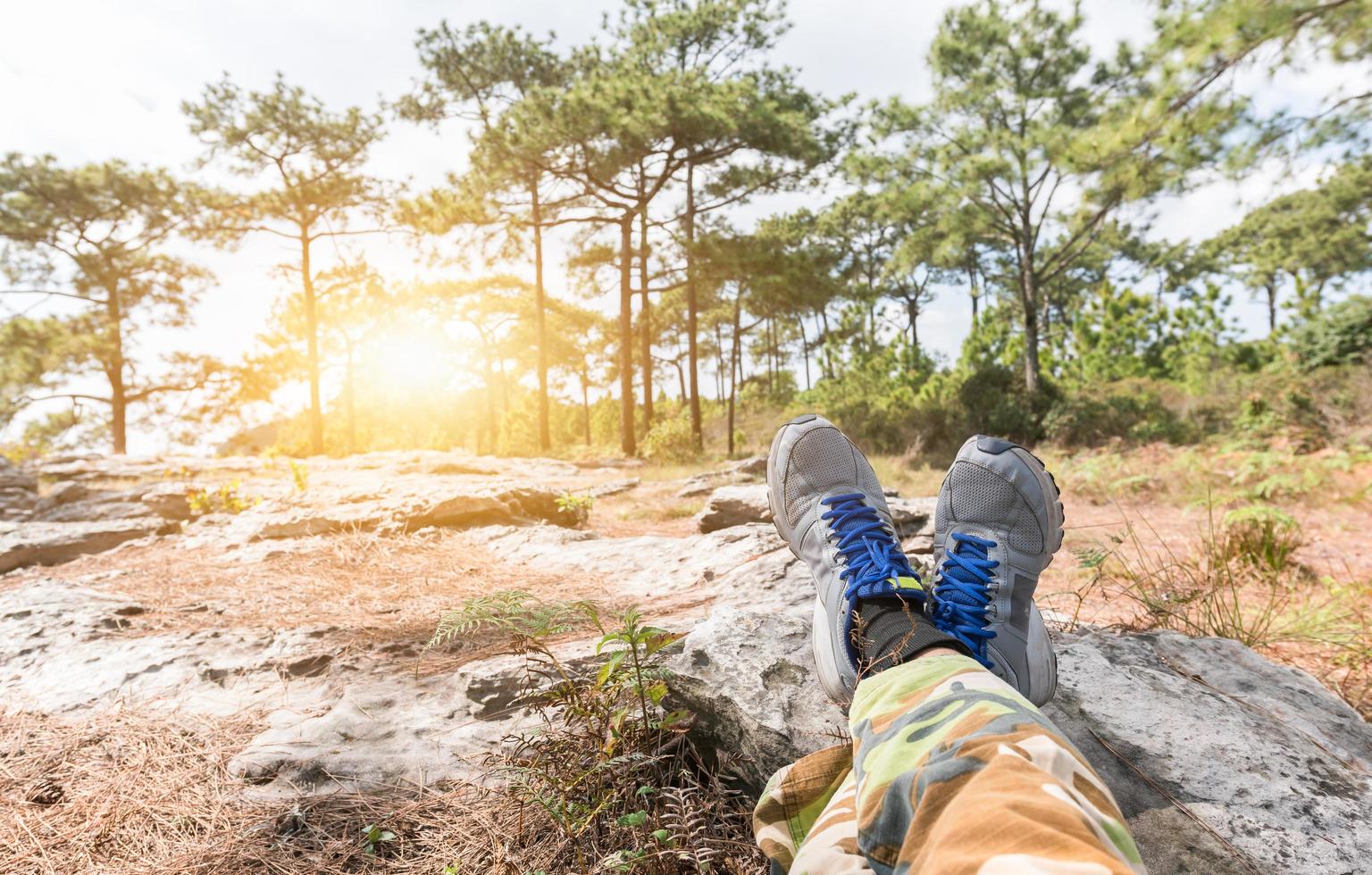 homme pieds dans baskets relaxant sur le Roche photo