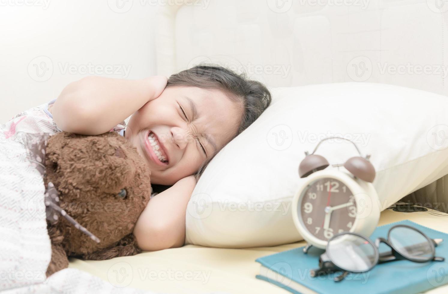 agacé fille étant éveillé par un alarme l'horloge photo