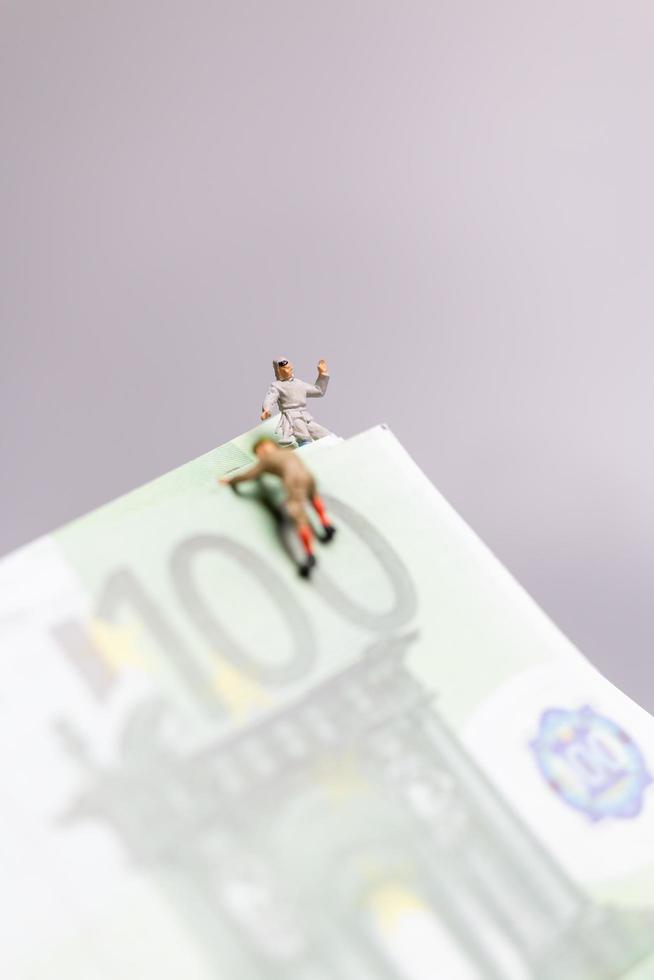 personnes miniatures, grimpeur grimpe sur un billet en euros, concept d'entreprise. photo
